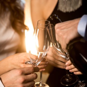 Close-up partial view of happy friends drinking champagne